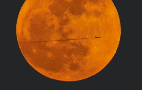 Photo of the Day: Jet streaks across supermoon in Taiwan